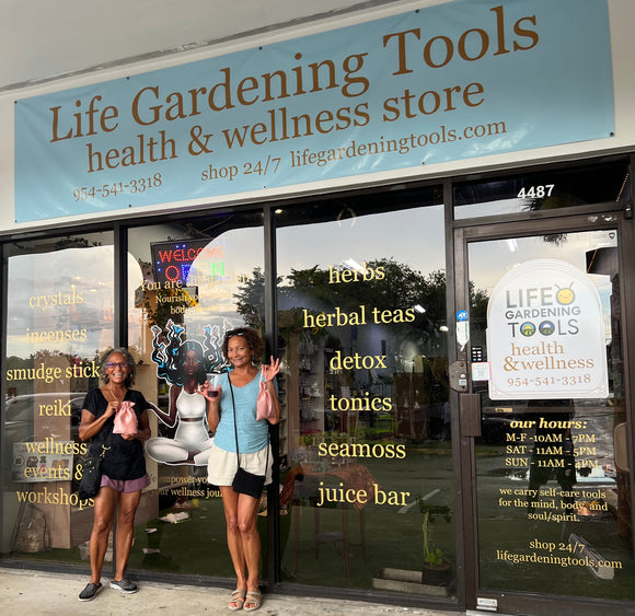 Storefront with a sign for 'Life Gardening Tools' and people inside.